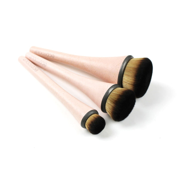 Three makeup brushes with pink handles, dark ferrules, and rounded golden bristle heads