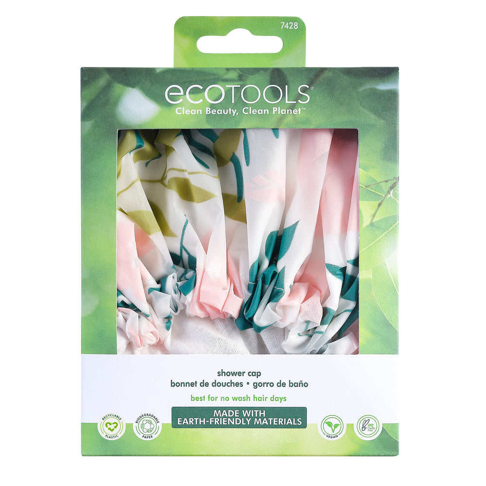 Printed shower cap with pink, green, and yellow tropical leaf pattern, elastic hem